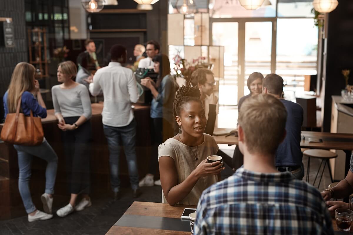 Customers talking and drinking coffee inside a boutique coffee shop