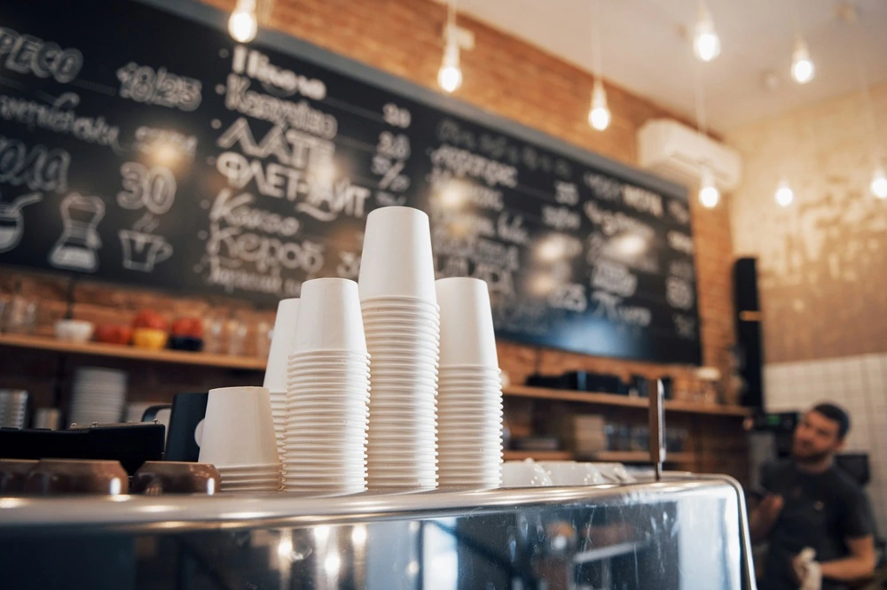 tacked compostable coffee cups on a café counter, ready for custom branding and takeaway service.